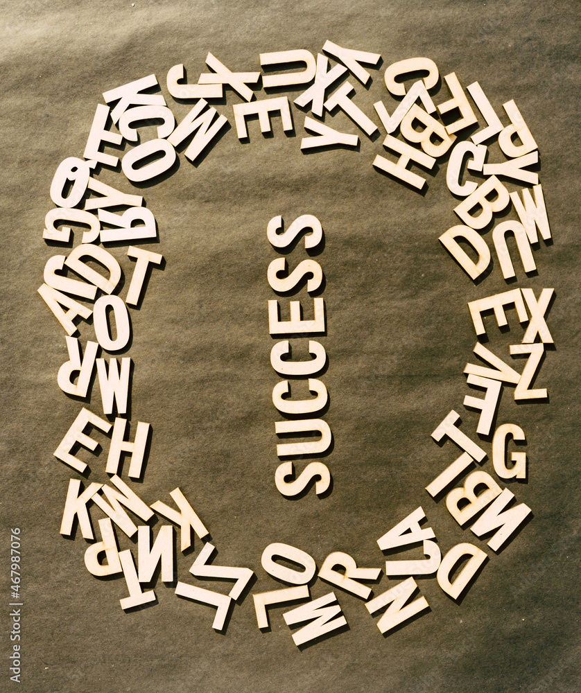 Fototapete success word in wooden cube alphabet letters top view on a rustic paper background.