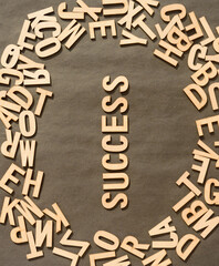 Success Word In Wooden Cube Alphabet Letters Top View On A rustic paper Background.