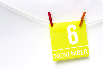 November 6th. Day 6 of month, Calendar date. Paper cards with calendar day hanging rope with clothespins on white background. Autumn month, day of the year concept.