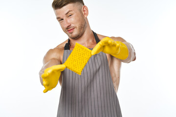 a man in a gray apron wearing rubber gloves cleaning washing