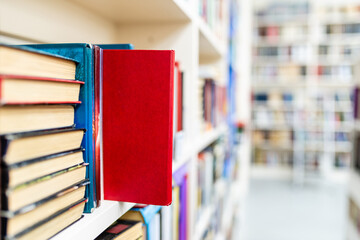 Library with bookcases. Many different books on the shelves. Large selection of books in a bookcase. Blur background.