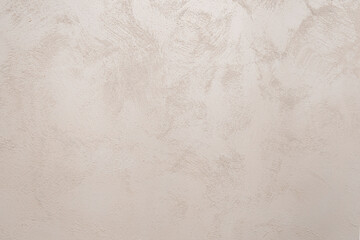 the texture of the plaster on the wall is beige