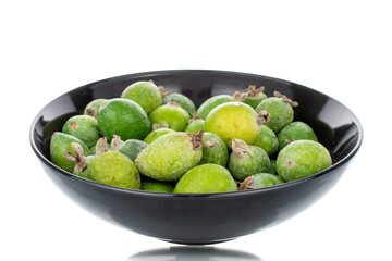 Several ripe sweet feijoa fruits with a ceramic plate, close-up, isolated on white.
