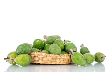 Several organic sweet feijoa fruits with straw dishes, close-up, isolated on white.