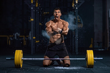 Fototapeta na wymiar Bodybuilder man. Muscular young fitness male have a workout with barbell in fitness gym.