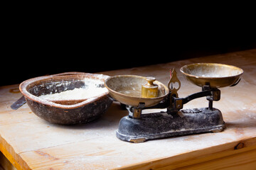 Old copper scales with flour stand on a wooden table in a bakery for bread