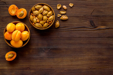 Apricots and apricot pits kernel in bowl. Overhead view