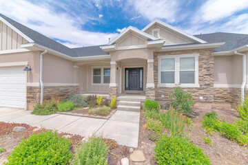 Facade of a house with grasses at the front surrounding the concrete path