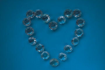 The heart is lined with transparent beads. Background of transparent crystals. Flat picture. Photographed from above. selective focus