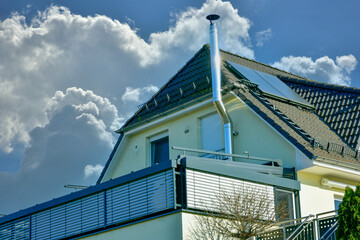 Schornstein, Außenkamin aus Edelstahl an der Fassade eines Wohnhauses