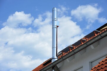 Schornstein, Außenkamin aus Edelstahl am Dach eines Wohnhauses
