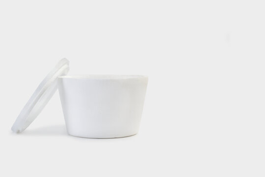 Cuenco de telgopor corcho blanco sobre un fondo gris claro liso y aislado. Vista de frente y de cerca. Copy space