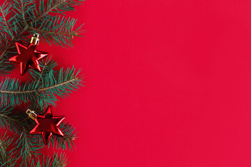 Christmas background with spruce branches and red ornaments.