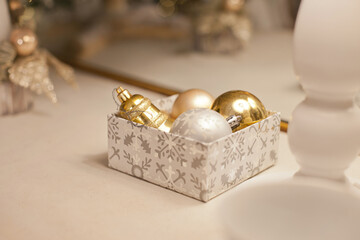 christmas ornaments decorations on mantelpiece at home in white gold colors