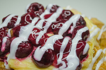 Puff with cherry and cream, photo on a white table