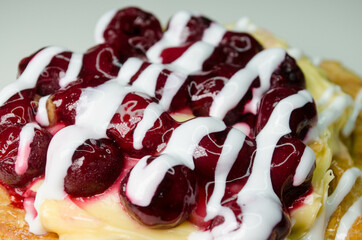 Puff with cherry and cream, photo on a white table