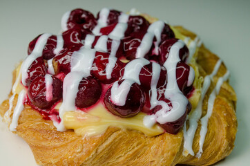 Puff with cherry and cream, photo on a white table