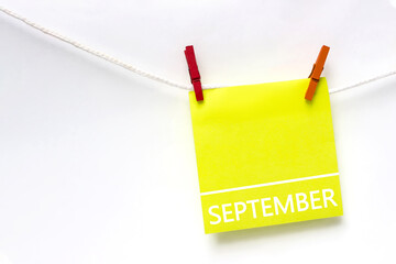 September. Month, Calendar month. Paper cards with calendar day hanging rope with clothespins on white background. Autumn , month of the year concept.