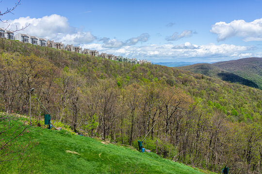 Wintergreen Ski Resort With Mountain Skiing Slopes By Snow Gun Machine In Virginia With Condo Condominium Buildings On Top Peak Of Blue Ridge Mountains In Spring