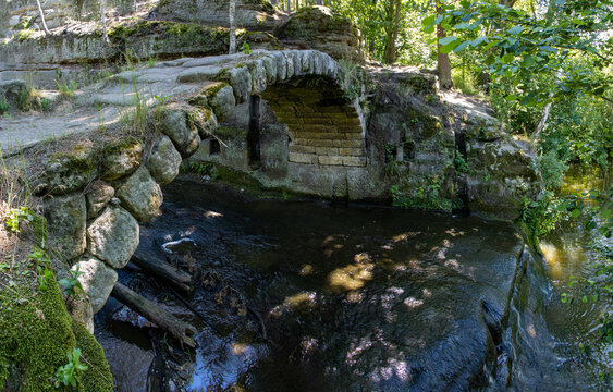 Old stone bridge over a stream in the woods