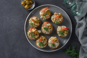 Shrimp, cheese and pineapple tartlets: a festive snack on gray background