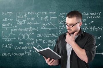 Young teacher man teaching holding book training the mathematics in classroom blackboard