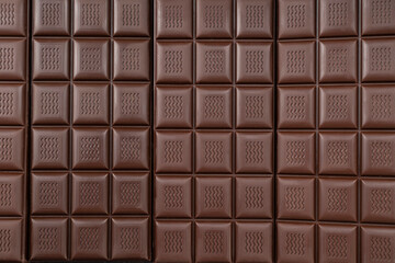 Handmade chocolate bar full frame. Black bitter craft chocolate on white background. Healthy food concept, delicious chocolate sweets, diet, sugar