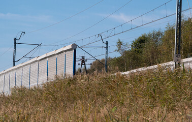 Railroad noise barrier. Acoustic wall reducing train sound. Soundproof protection fence along the railway.