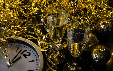 Two glasses of champagne, golden decorations and clock approaching midnight. New Year's Eve celebration composition. - obrazy, fototapety, plakaty
