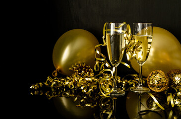 Two glasses of champagne, golden balloons and decorations. New Year's Eve celebration composition. - obrazy, fototapety, plakaty