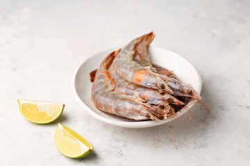 Tiger prawns with lime. Raw seafood on a light background. Fresh shrimp in a plate