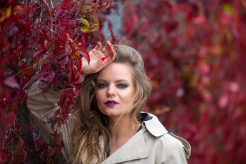 Portrait of stylish sexy woman with makeup and manicure in trench coat