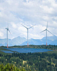 green energy, solar panels and wind power station on mountain