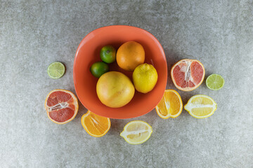 Different, beautiful citrus fruits on a gray background.