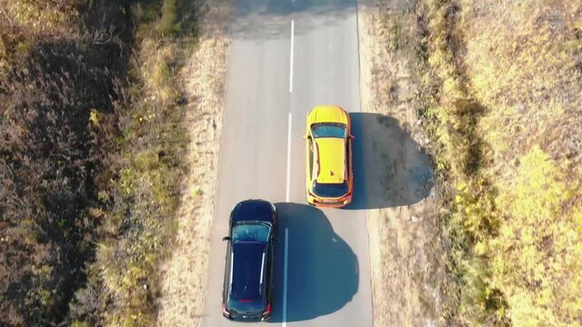 two crossovers are driving on autumn road	
