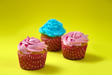 Cupcake con glaseado de colores sobre fondo amarillo