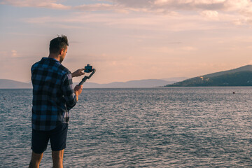 The use of technology. A male videographer shoots nature using a smartphone on a steadicam. © Сергей Петросянц