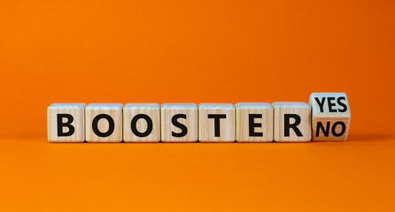 Covid-19 booster vaccine shot yes or no symbol. Turned a wooden cube and changed words booster no to booster yes. Beautiful orange background, copy space. Covid-19 booster vaccine shot concept.