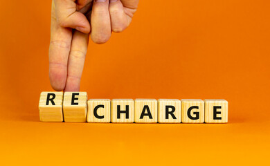 Charge or recharge symbol. Businessman turns wooden cubes and changes the word 'charge' to...