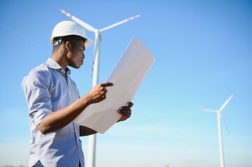Engineer checks Wind Turbine system with a tablet. Alternative Energy. Wind farm. Clean renewable energy technologies. Wind power plants