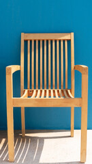 Yellow wooden chair on the background of the blue wall