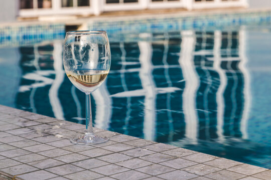 crystal glass with white wine by the pool, Alcohol at the hotel