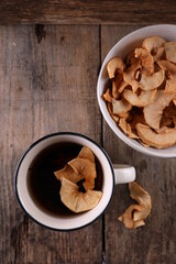 Dried apples in a bowl against a dark old wooden background