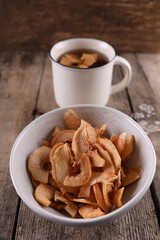 Dried apples in a bowl against a dark old wooden background