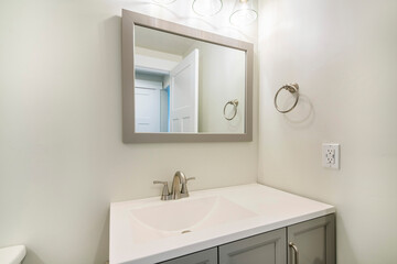 Naklejka na ściany i meble Single vanity sink in a small white bathroom with towel ring holder