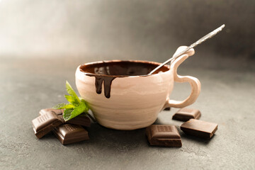 Hot chocolate in bowl, side view with mint leaves. Chocolate paste in a cup and mints leaf. Recipe Cooking handmade chocolate bar, dessert, candies. Confectionery covered with chocolate topping © Alex Desanshe