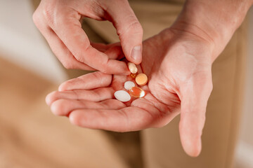 The man holds pills and capsules in his hand. Taking vitamins and medications, close up