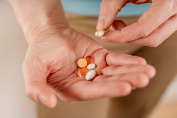 The man holds pills and capsules in his hand. Taking vitamins and medications, close up