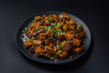 fried tofu on a black background