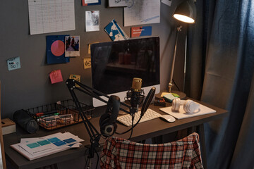 Image of computer monitor and microphone on the table for online work in domestic room